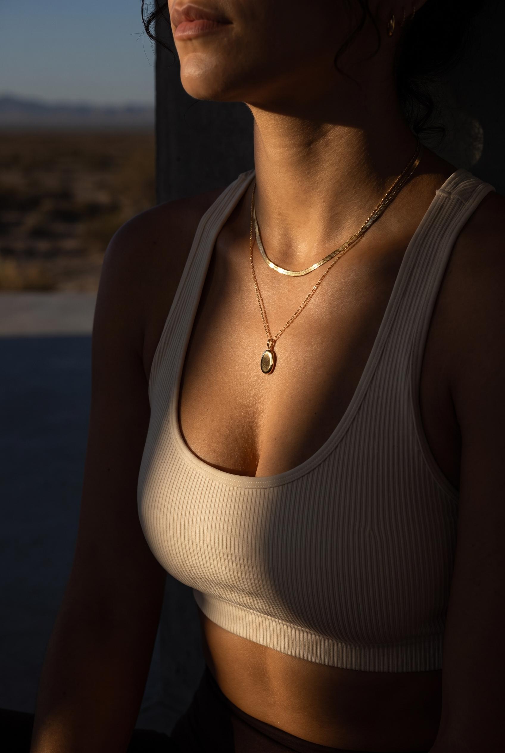 Layered gold necklaces at desert golden hour