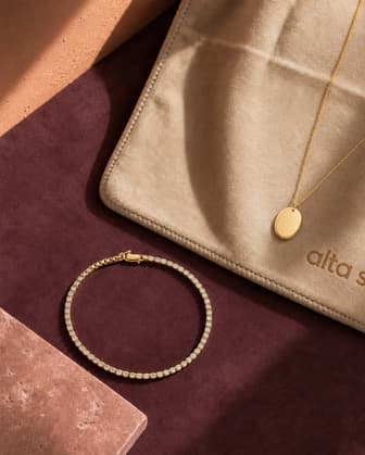 Gold Athleia jewelry resting on a yoga mat with a training mat
