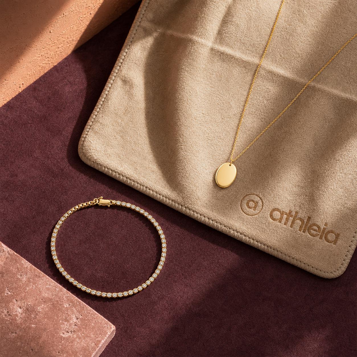 Gold Athleia jewelry resting on a yoga mat with a training mat