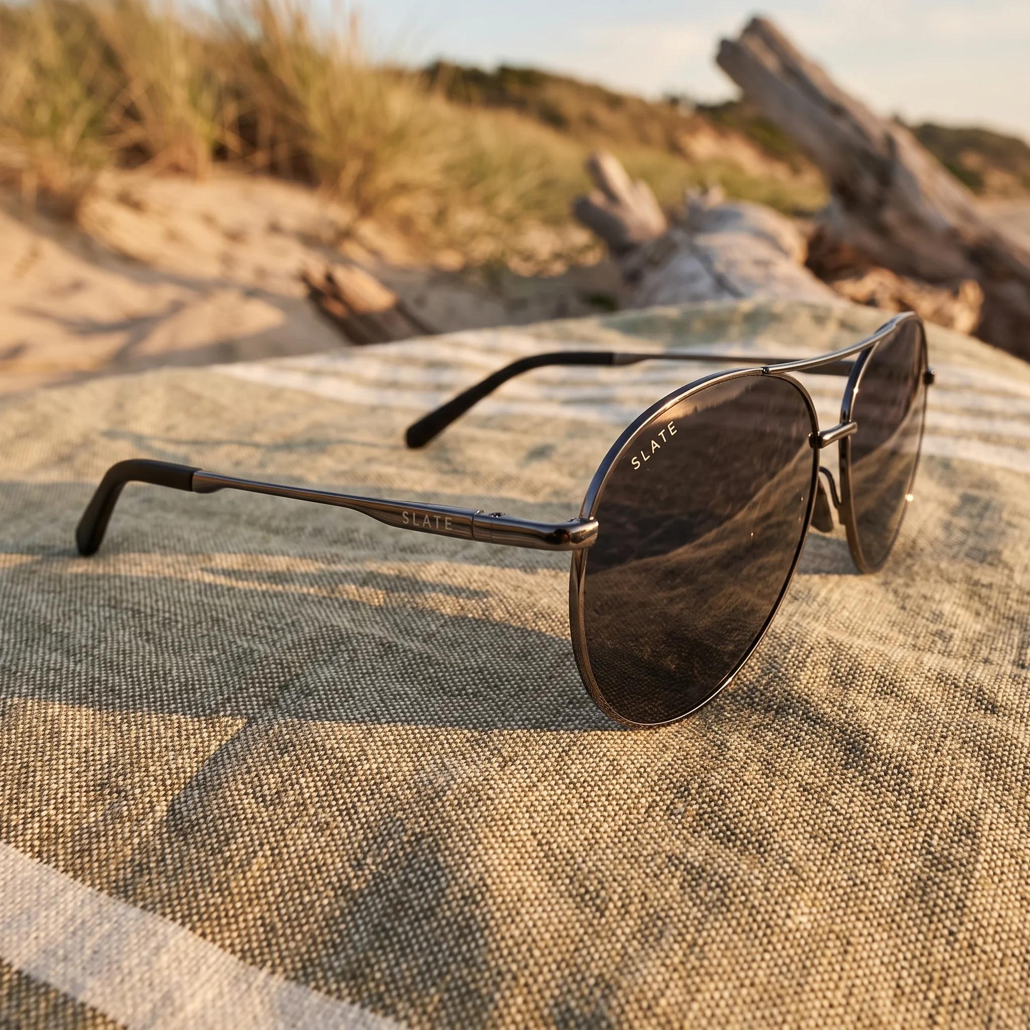 Slate Basin sunglasses in smoke gray translucent acetate on sunlit stone