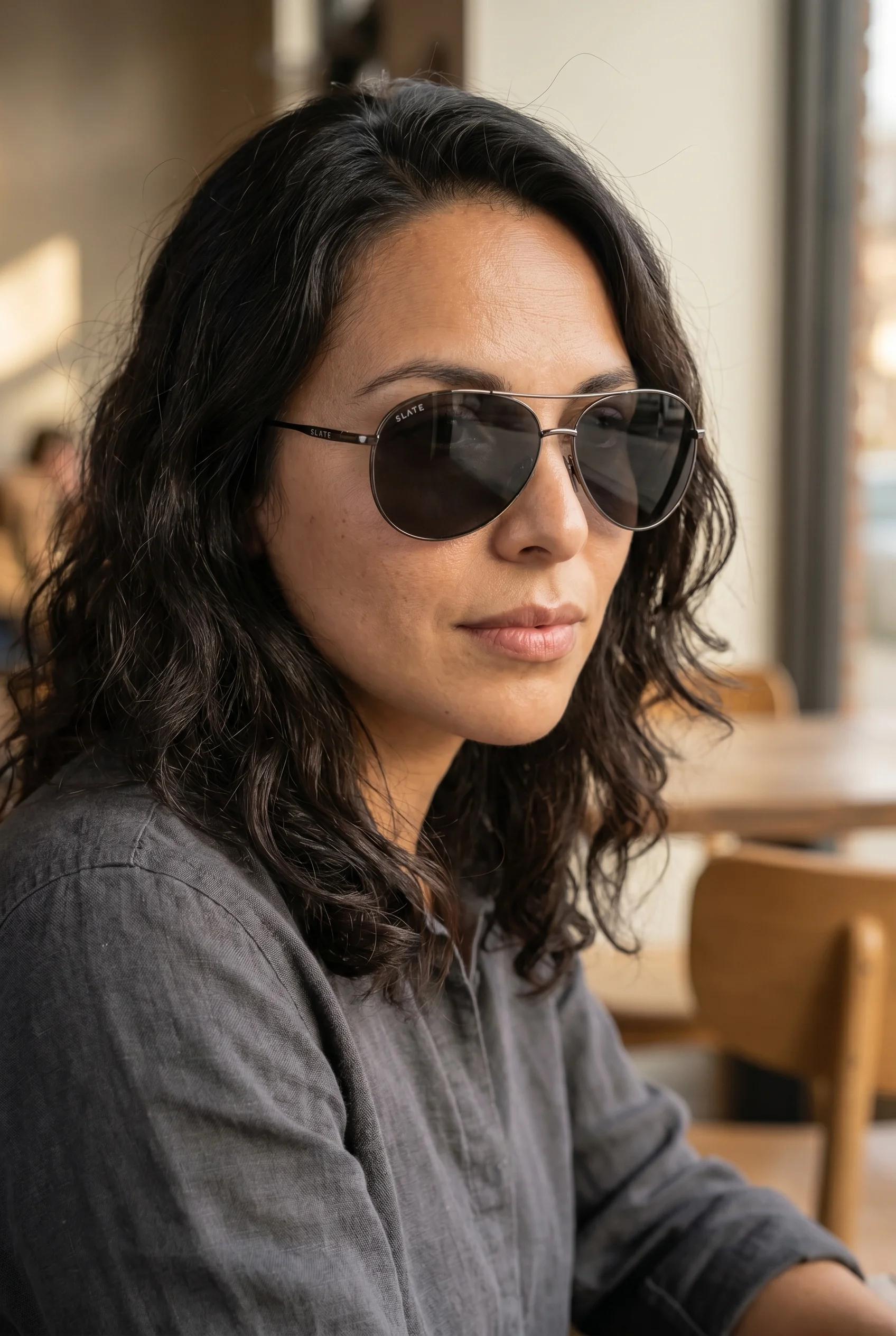 Woman wearing Slate sunglasses in warm indoor light